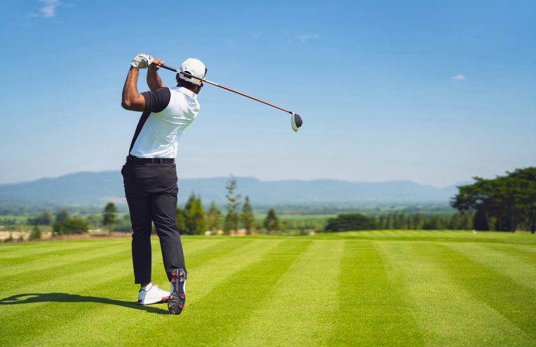 Asian man golfing on the course